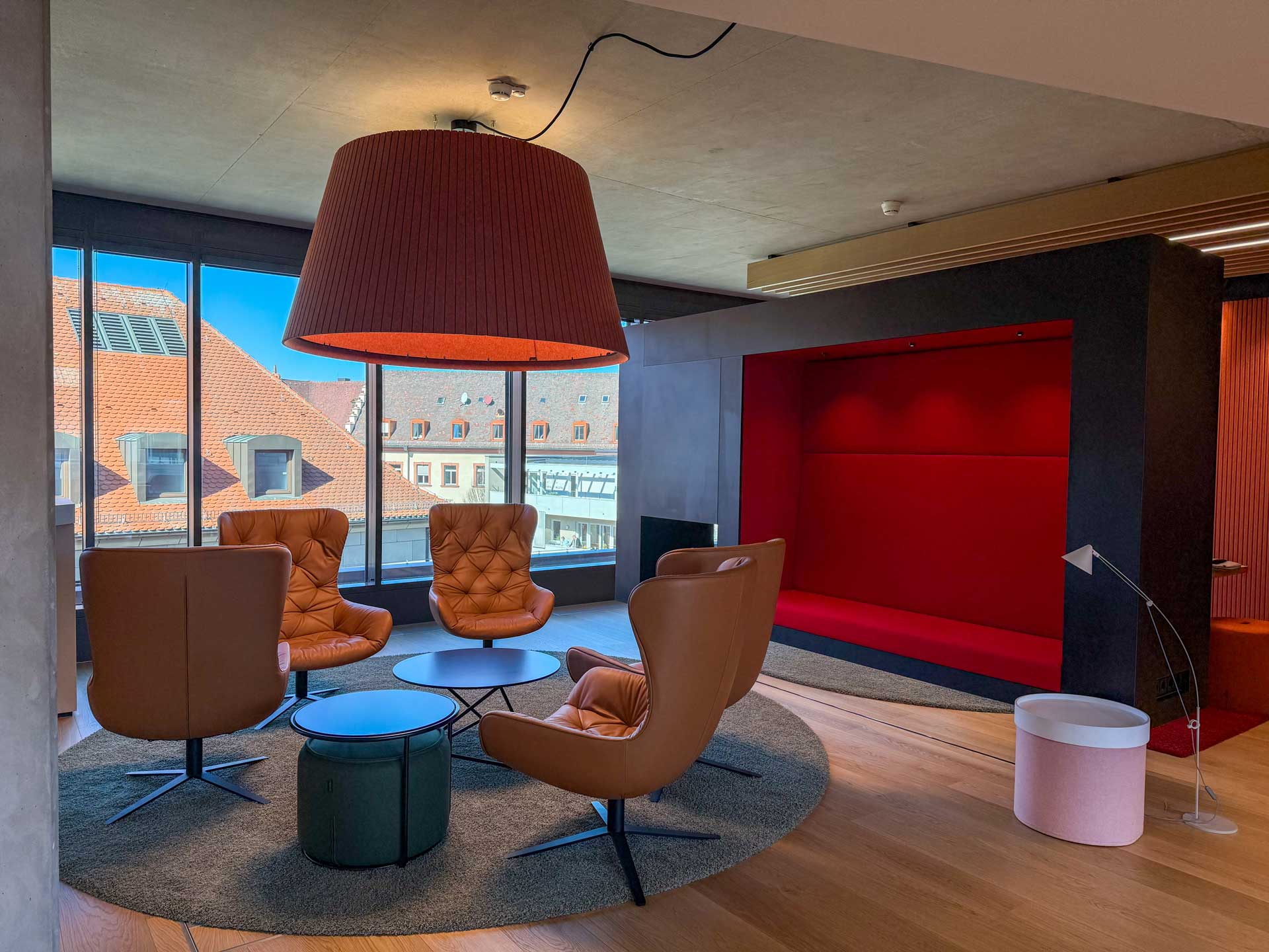 Lounge mit Ledersesseln unter einer großen Pendelleuchte