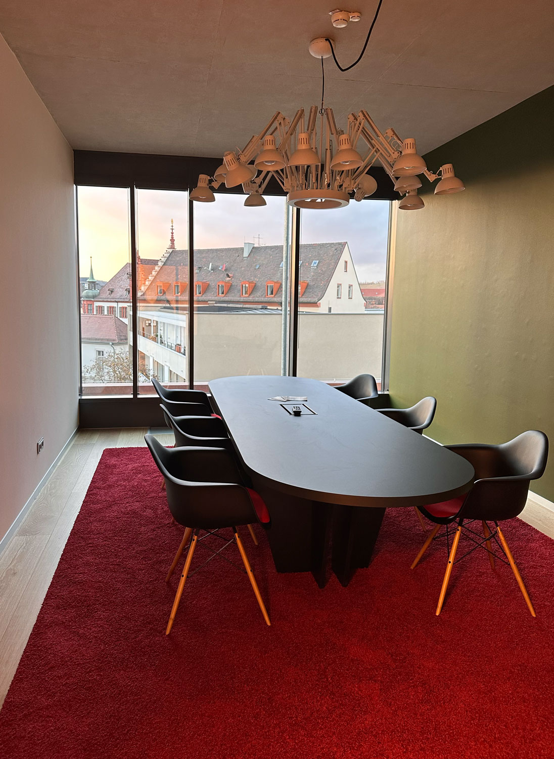Besprechungsraum mit ovalem Tisch und rotem Teppich
