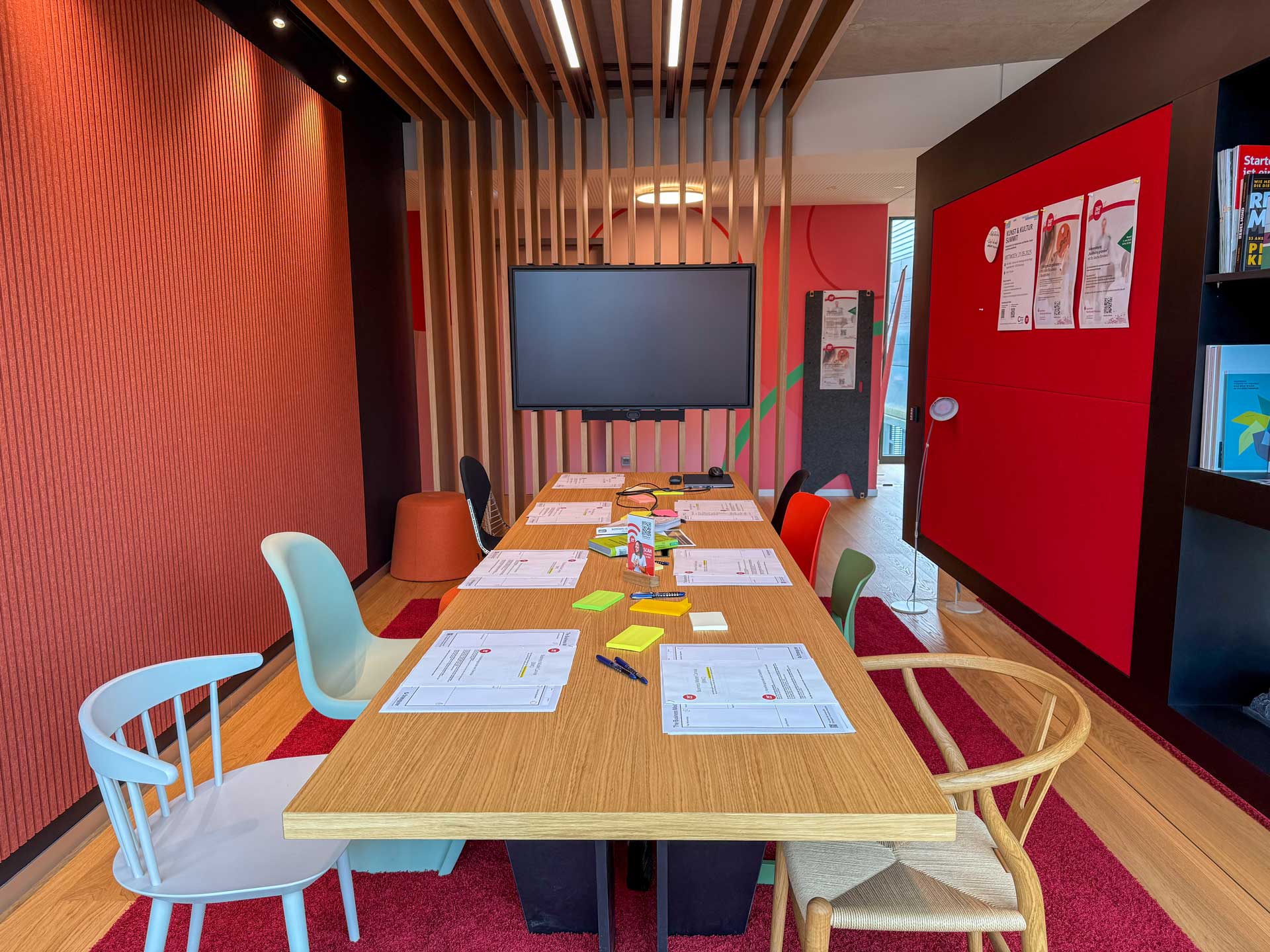 Seminarraum mit langer Tafel und Bildschirm